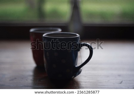 Isolated image of Two mugs filled with tea on a table, ready to be enjoyed in the evening, savoring the sunset and the warmth of rose tea.