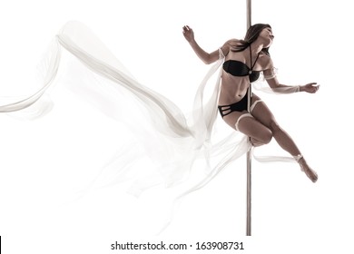 Isolated image of a young woman full of lightness in pole dance with white cloth over a white background