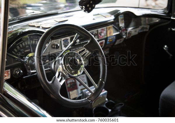 Isolated\
Interior View of Restored Tricked Out Vintage 50s Automobile\
Dashboard, Steering Wheel,  and Fabric\
Seats
