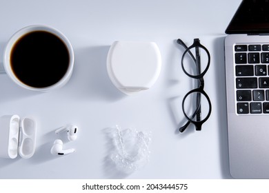 Isolated Invisible Aligner Braces Composed With Laptop, Coffee, And Ear Phones Concept.