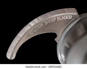 Isolated Macro Photo Of The Very Sharp Blade Of Food Processor Or Blender With Warning Engraving About Danger