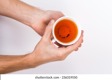 Isolated Male Hands Holding A Cup Of Tea. View From Above.