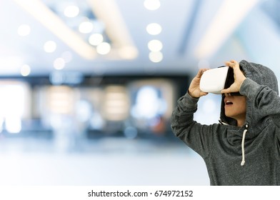 isolated man using VR glasses on on shopping mall background