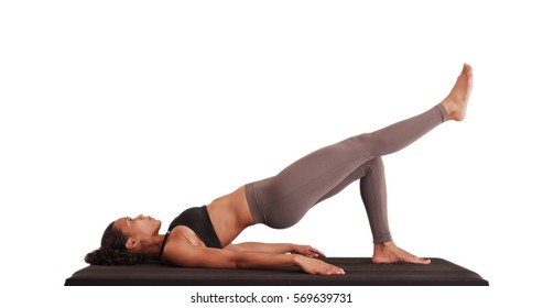 Isolated mixed race woman athlete doing hip raises on matt