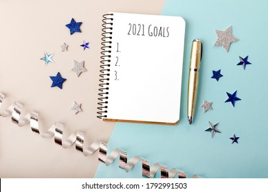 Isolated Notebook And Gold Pen On The Festive New Year Background.Notepad With 2021 Goals.Concept Of Making New Year Plans And Resolutions.