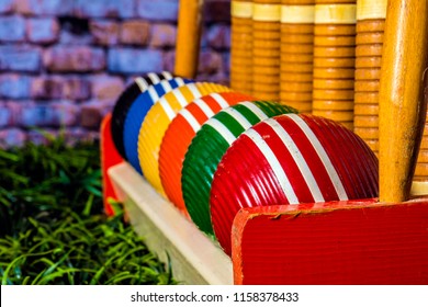 isolated old croquet set with colorful striped wooden balls on green grass
