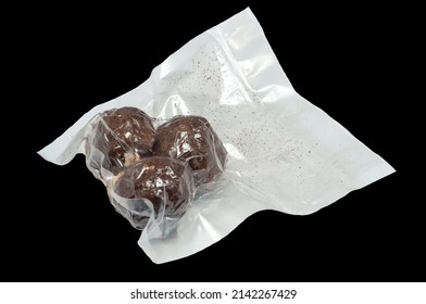 isolated on a black background are three balls of Belper Knoll cheese in a vacuum package. Hard Swiss cheese in the form of small balls, sprinkled with black pepper.