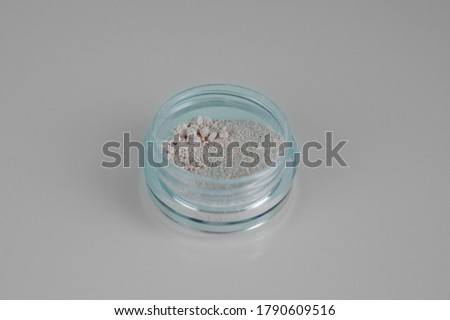 Isolated on light background makeup beauty cosmetics product & facial cosmetic, colourless mineral powder. Macro photo.