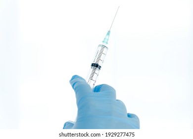 Isolated On White Background: Doctor's Hand In Glove Holds A Syringe Vaccination Against Covid Concept.
