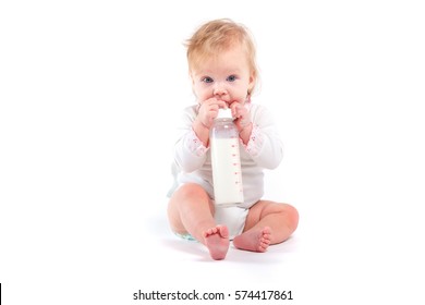 Isolated On White, Cute Happy Caucasian Baby Girl In White Shirt Hold Milk Bottle, Try To Drink