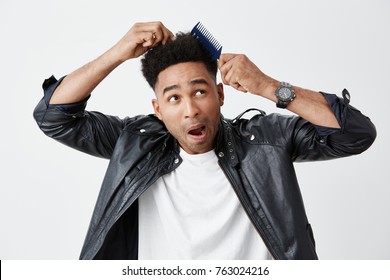 Isolated On White Portrait Of Young Dark-skinned Funny Man With Afro Hairstyle In Casual Clothes Being Shocked That His Comb Stuck In His Hair. Bad Beginning Of Day.