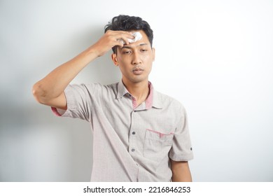 Isolated On White Studio Background Overheated Sweaty Young Man Suffering From Heat Stroke Or High Temperature, Using Paper Napkin. Head Shot Close Up Portrait Tired Millennial Guy Feeling Unhealthy.