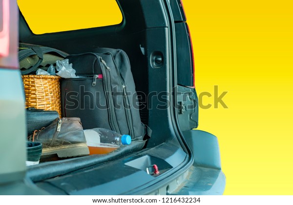 isolated opened car trunk with luggage on
yellow background