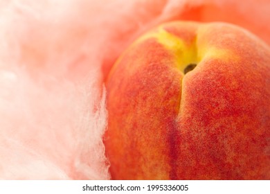 Isolated peach facing upward, cheeks blushed, full rounded shoulders, nestled against soft pink cotton candy. Texture visible. - Shutterstock ID 1995336005