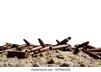 Isolated Photo Of Metal Bullet Gun Shells Laying On Sand Surface.