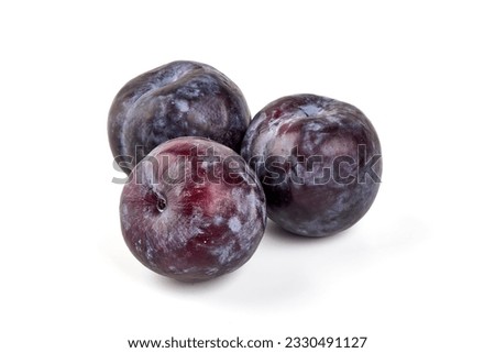 Isolated plums. One and a half of blue plum fruit with leaves isolated on white background