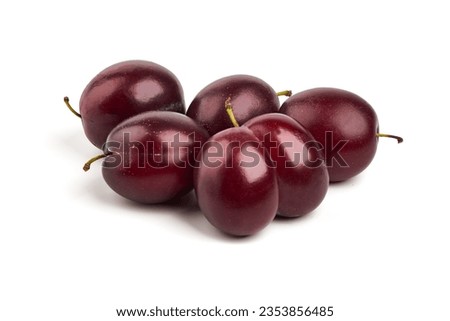Isolated plums. One and a half of blue plum fruit with leaves isolated on white background