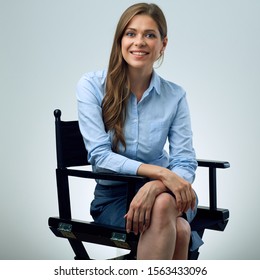 Isolated Portrait Of Young Woman Sitting On Movies Director Chair. Isolated Female Portrait.