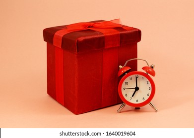 An Isolated Red Gift Box And Alarm Clock To Represent That Theres No Time Like The Present.