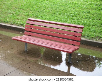 Isolated Red Wood Park Bench On A Rainy Day