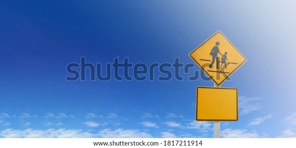 Isolated school zone sign on pole with cloudy\
bluesky background.