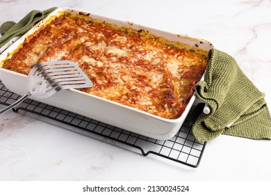 An Isolated Serving Of Vergetarian Lasagna In A White Casserole Dish