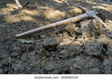 An isolated shot of a hand pickaxe lying in the soil.