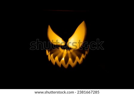 An isolated shot of a light reflection forming a monstrous face on a black background