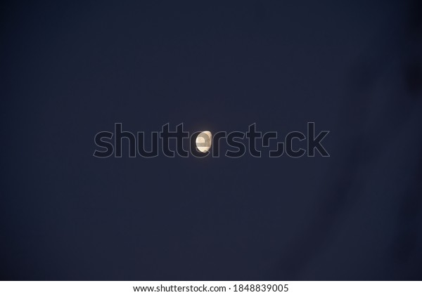 An isolated shot of the moon, at dawn in Rovaniemi,\
Lapland, Finland. Shadows and craters can be seen in the lunar\
landscape.        