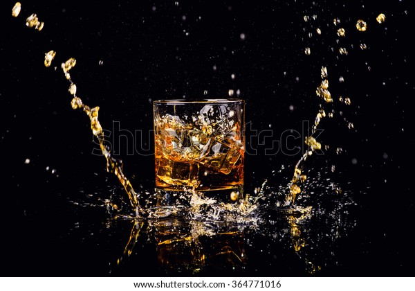 Isolated\
shot of whiskey with splash on black\
background