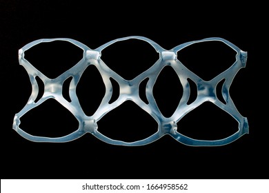 Isolated six pack rings or six pack yokes, connected plastic rings used in multi-packs of beverage on a black background - Shutterstock ID 1664958562