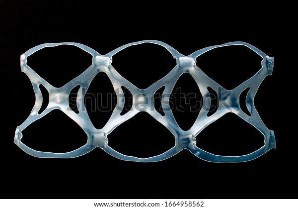 Isolated\
six pack rings or six pack yokes, connected plastic rings used in\
multi-packs of beverage on a black\
background