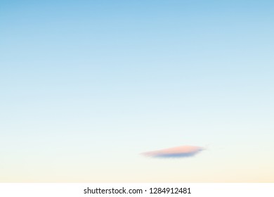 Isolated small cloud on a bright blue sky with vibrant colors during sunset in northern Sweden close to Kebnekaise mountain. 