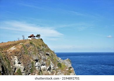 Isolated Small House On A Rock Beside The Blue Ocean Sea At High Ground. Nature. Negative Copy Space Blue Sky. Serenity. Ambiance. Calm