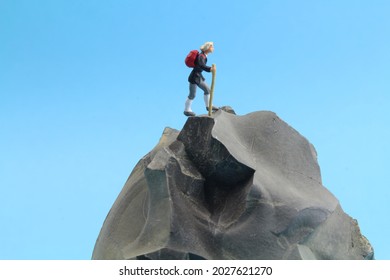 isolated stone with a figure of a hiker and blue background 