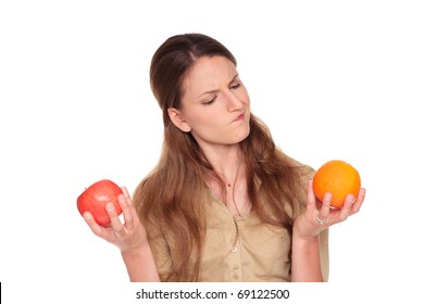 Isolated studio shot of a Caucasian businesswoman making a difficult choice between an apple and orange
