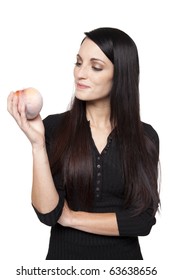 Isolated studio shot of a dark haired caucasian woman looking happily at a fresh peach.