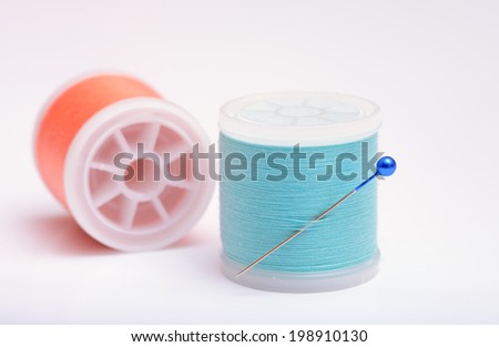 Isolated thread spools with pin on white background