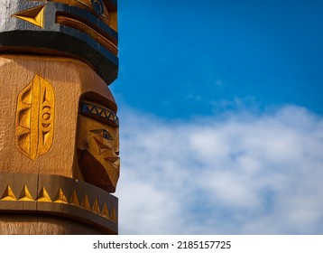 Isolated totem wood pole in blue sky background. Indian totem poles in park in Nanaimo, Canada. Travel photo, copy space for text, nobody