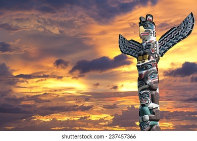 Isolated totem wood pole in the gold sunset background