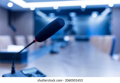 Isolated view of a microphone in the front of a conference room among blurred other mikes in the background
