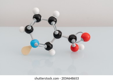 Isolated vitamin B3 made by molecular model with reflection on white background. Niacin chemical formula with colored atoms and bonds