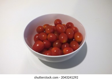 Isolated white bowl of cherry tomatoes on a white background