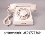 Isolated white vintage dial telephone. Analog communication system. Old fashioned telephone 50s