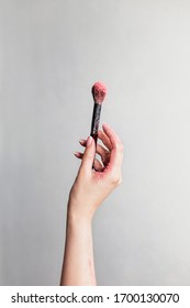 Isolated Woman Hand Holding Makeup Brush. Grey Background