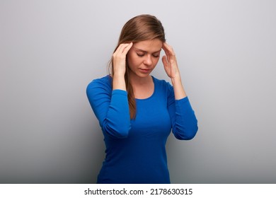 Isolated Woman Headache With Hands On Head. Female Portrait With Closed Eyes In Blue Shirt. Head Tilt Down.