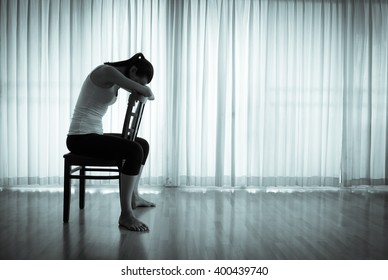Isolated woman sitting on a chair feeling upset and sad.