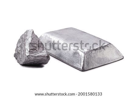 Isolated zinc ingot or bar next to raw zinc nugget on isolated white background, metal used in alloy and steel production.