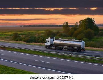 Isothermal Tank truck driving on highway. Oil and Gas Transportation and Logistics. Metal chrome cistern tanker with petrochemicals products. Liquid Chemical Freight. Out of focus
