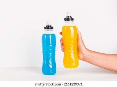 Isotonic Sport Water Energy Drink Copy Space White Background. Woman Hand Hold Bottle With Yellow Hydration Sport Beverage.